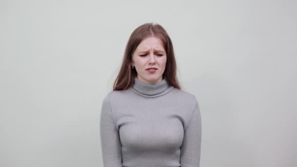 une jeune belle femme aux cheveux rouges en pull gris déçue de mauvaise humeur
 - Séquence, vidéo