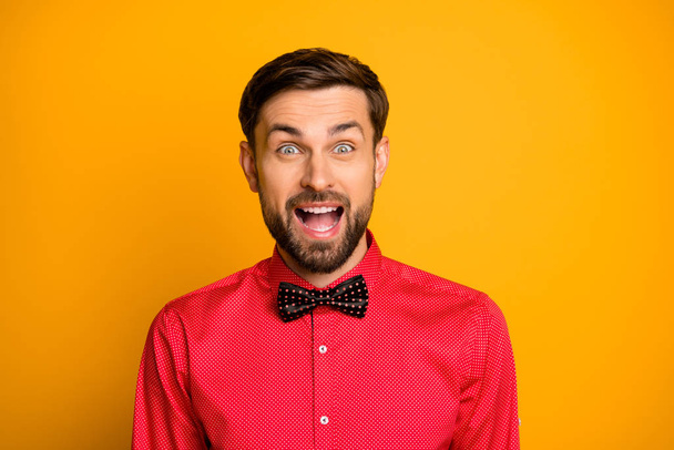 Wow. Photo of funny macho guy good mood friendly smiling enjoy unexpected surprise open mouth wear stylish red shirt with black bow tie isolated yellow color background - Foto, Imagem