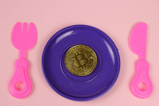 Een metalen Bitcoin munt ligt in een plastic plaat - Foto, afbeelding