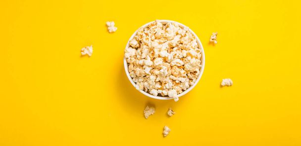 Popcorn viewed from above on yellow background. Flat lay  bowl.  - Foto, Bild
