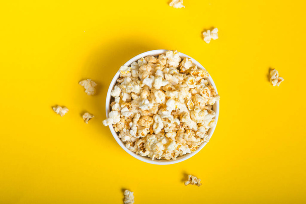 Popcorn viewed from above on yellow background. Flat lay  bowl.  - Fotoğraf, Görsel