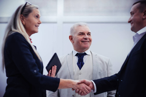close up. smiling business partners shaking hands. - Φωτογραφία, εικόνα