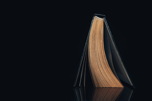 デザインのための美しい古代の本のパターンの背景。黒いガラスのテーブルの背景の本. - 写真・画像