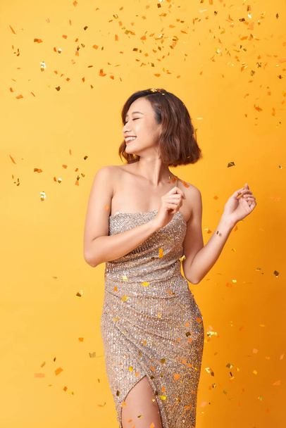hermosa mujer sexy en vestido de noche celebrando, confeti de oro, fiesta, sonriendo, invitando, feliz
 - Foto, imagen