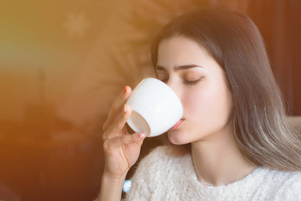 kahvilan tyttö juo kuumaa kahvia, hän todella pitää siitä, hän nauttii
 - Valokuva, kuva