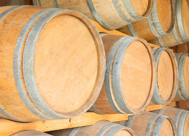 Круглі дерев'яні бочки для вина на полиці підвалу
. - Фото, зображення