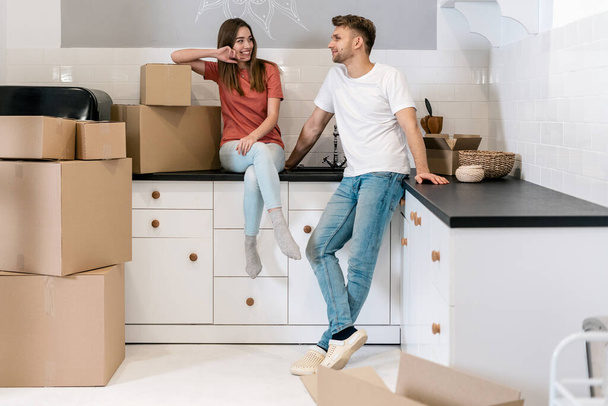 Young couple with cardboard boxes moving in new house - Foto, immagini