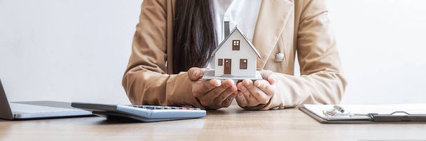 Modello di casa sulla mano agente che mostra ai clienti di acquistare, ottenere l'assicurazione, prestito immobiliare o proprietà. - Foto, immagini