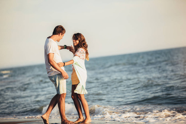 Young couple in love on the beach . Handsome young man with girl - 写真・画像