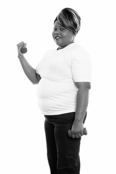 Studio shot of beautiful overweight African woman isolated against white background in black and white - Zdjęcie, obraz