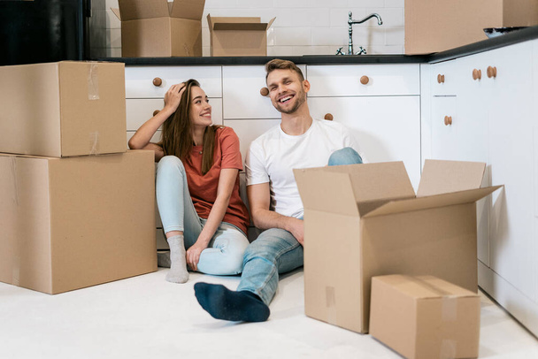 Hombre y mujer adultos jóvenes con cajas de cartón que se mueven en un nuevo hogar
 - Foto, imagen