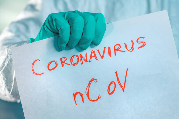 Epidemiologist holding Coronavirus bCoV paper banner in quaranti - 写真・画像