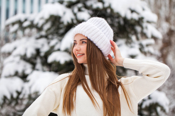 Young beautiful woman in a woolen sweater posing on a background - 写真・画像