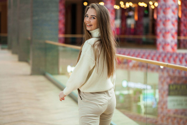 Portrait of a young beautiful woman in beige sweater and pants p - Foto, Imagen