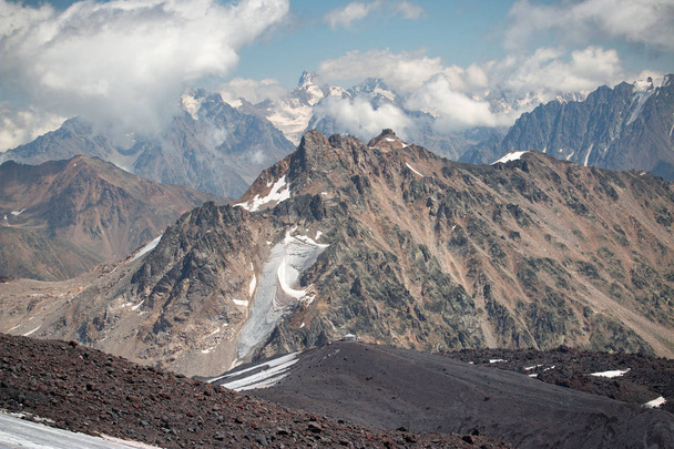 Caucasus mountains near Elbrus volcano with glaciers, clouds and peaks. - Fotoğraf, Görsel