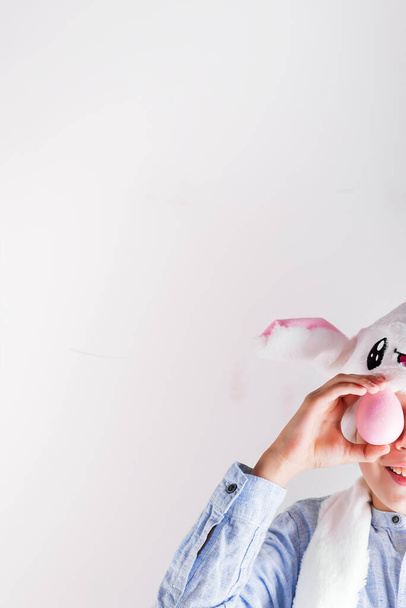 Счастливый мальчик в кроличьей шляпе с пасхальными яйцами в руках на серой стене, скопировать пространство
 - Фото, изображение