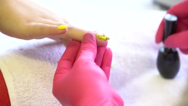 closeup shot of a beautician applying nail polish to female nail in a nail salon close up of a woman hand with yellow nail polish after the manicure  - Footage, Video
