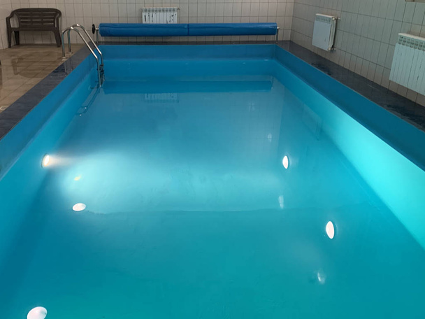 kleiner Pool mit klarem Wasser im Wellnessbereich. Beleuchtetes Hallenbad. - Foto, Bild