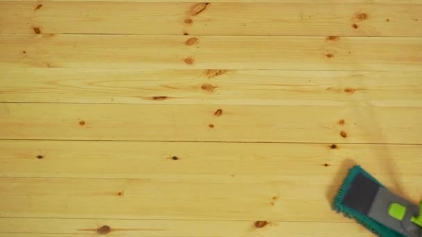 abgeschnittenes Bild der schönen jungen Frau in Schutzhandschuhen mit einem flachen feuchten Wischmopp beim Putzen des Fußbodens im Haus - Filmmaterial, Video