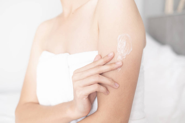 Mujer que aplica crema de brazos, loción, concepto de cuidado corporal de la piel higiénica - Foto, imagen