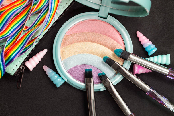 Rainbow glitter oogschaduw palet en make-up borstels op een donkere achtergrond - Foto, afbeelding