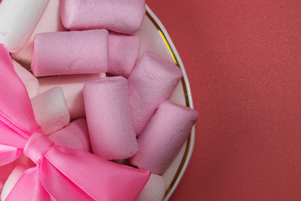 Marshmallows sweets with a pink bow on a saucer. - Photo, Image