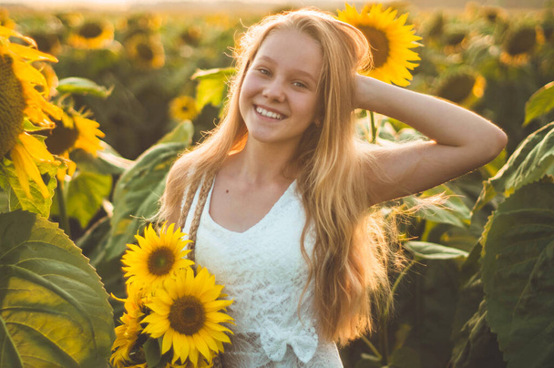 Hermosa joven en un campo de girasol. Retrato de una joven al sol. Concepto de alergias al polen
. - Foto, Imagen