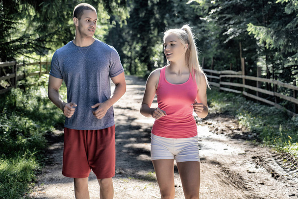 Futó fitness pár futók sportolnak a szabadban. Aktív élő férfi és nő kocogás képzés kardió nyáron szabadban természet. - Fotó, kép