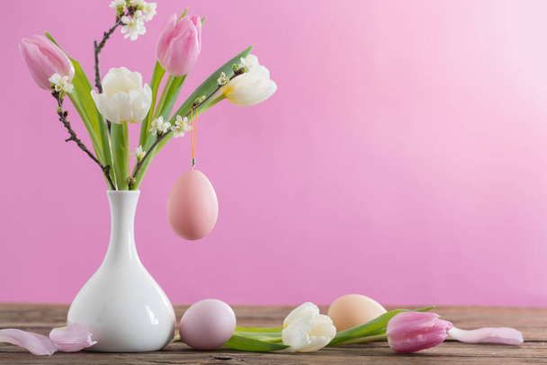 Easter eggs and tulips in vase on pink background  - Zdjęcie, obraz