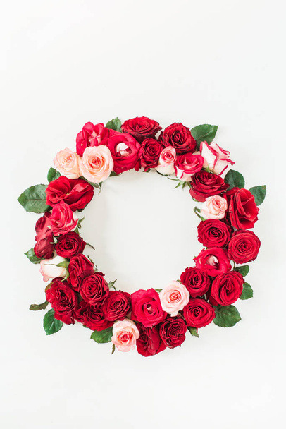 Round frame border of pink, red rose flowers on white background. Mockup blank copy space. Flat lay, top view floral composition. - Foto, afbeelding