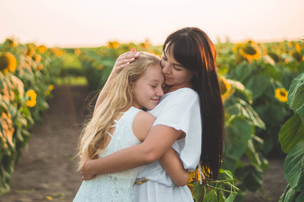 Счастливая мать и ее дочь-подросток на подсолнечном поле. Счастье на открытом воздухе
 - Фото, изображение