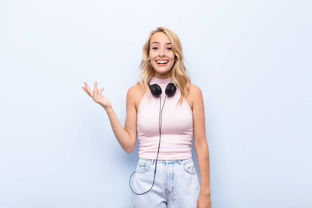 young blonde woman feeling happy, surprised and cheerful, smiling with positive attitude, realizing a solution or idea listening music - Fotografie, Obrázek