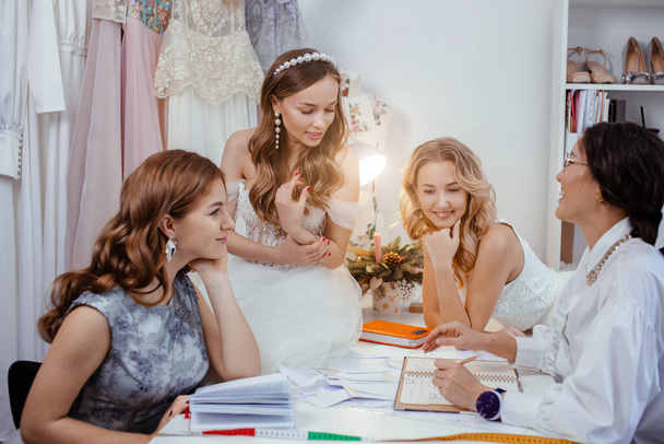 cheerful group of models with professional designer of dresses - Фото, изображение