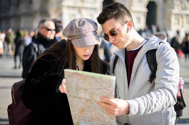 Couple of tourists in the city looking at a map and discussing about the next destination - Foto, Imagem