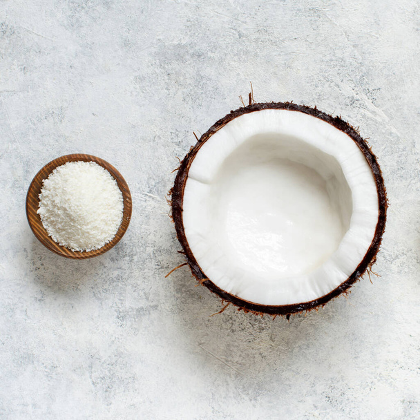 Coconut flour in a wooden bowl and a half of coconut - Photo, Image
