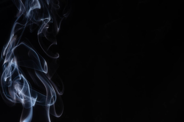 Abstract puffs of smoke on the left side of the frame on a dark background with a place for text, mysticism, fantasy - Foto, Imagem