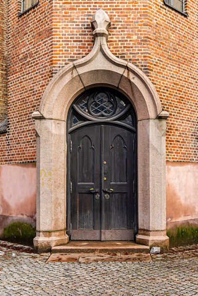 Fekete fa ajtó egy régi tégla katedrális - Fotó, kép