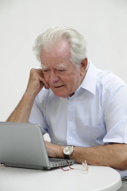 Senior άνθρωπος που χρησιμοποιεί φορητό υπολογιστή στο σπίτι - Φωτογραφία, εικόνα