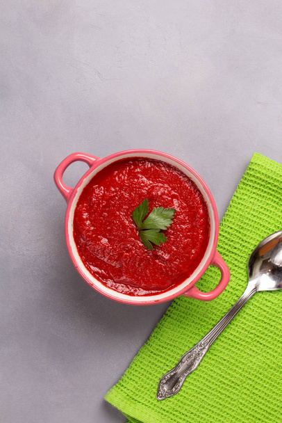 Tomato soup with parsley, onion and garlic on gray background. Comfortable food. Rustic style. Copy space. - Φωτογραφία, εικόνα