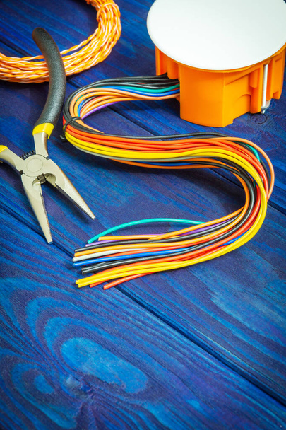 通常、電気インストールプロセスで使用されるワイヤとツールと電気接合オレンジボックス - 写真・画像