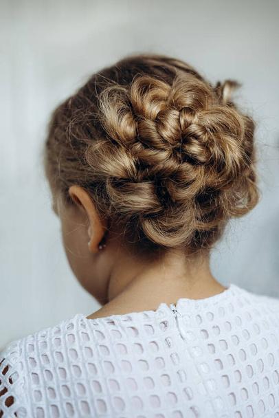 festliche Frisur aus Zopf auf einem Kindermädchen mit langen Haaren, Rückseite - Foto, Bild