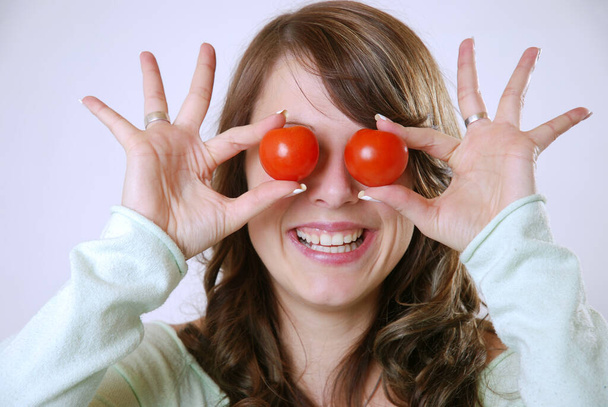 young woman with tomato in hands - Fotoğraf, Görsel