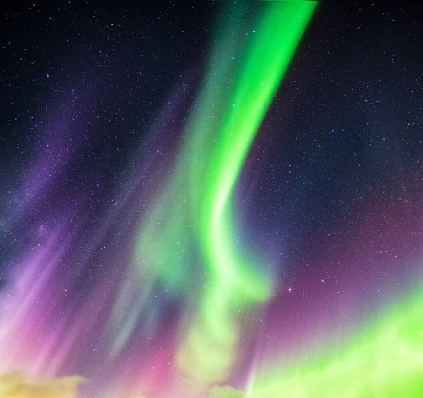 Aurora Borealis ya da Kuzey ışıkları yeşil ve mor renkli  - Fotoğraf, Görsel