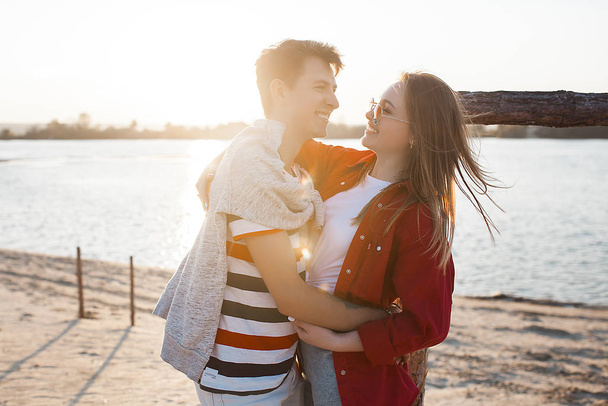 Pretty couple having fun at the sea shore. Love and relationship concept. Romantic background.Young woman and man together walking the coast line. - Photo, Image
