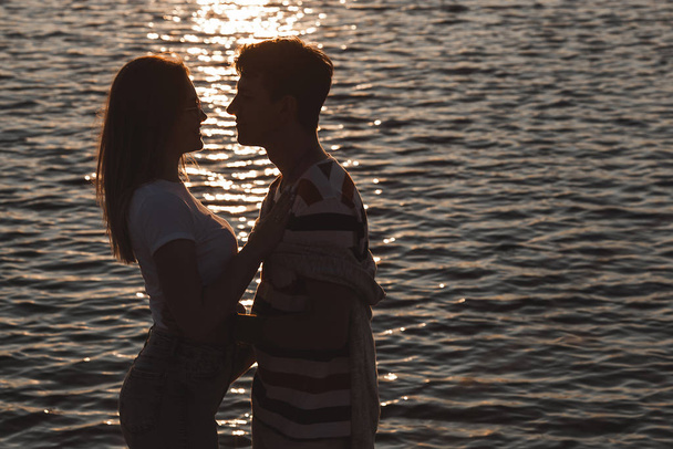 かなりのカップルが海の海岸で楽しんでいます。愛と関係の概念。ロマンチックな背景.一緒に海岸線を歩いて若い女性と男. - 写真・画像