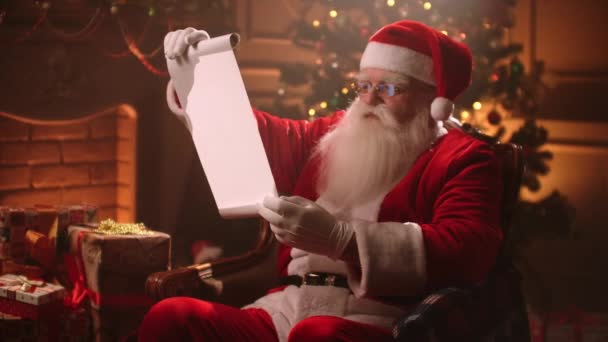 Санта Клаус тримає старий сувій пергаменту, Лист, пустий. Посмішка Санти з сувоєм. Santa list- Santa Claus утримує сувій - Кадри, відео