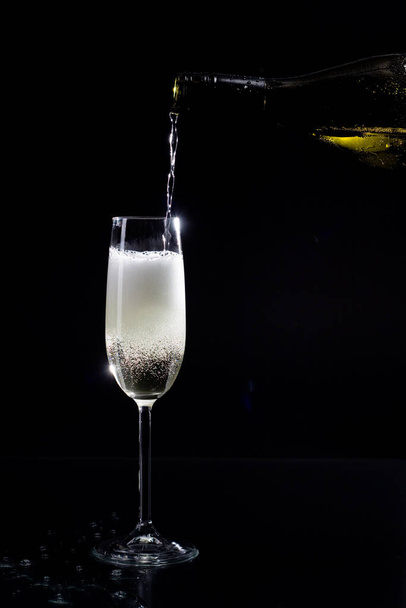 champagne glass with bubbles on black background - 写真・画像