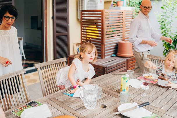 perhe naispuolisten lasten kanssa ulkona istuva pöytä aamiaisella
 - Valokuva, kuva