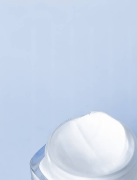 Krém na obličej zvlhčovač sklenice na modrém pozadí, hydratační pleť - Fotografie, Obrázek