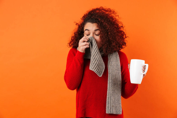 Sick young sneeze woman holding cup of hot tea wearing scarf. - Foto, imagen